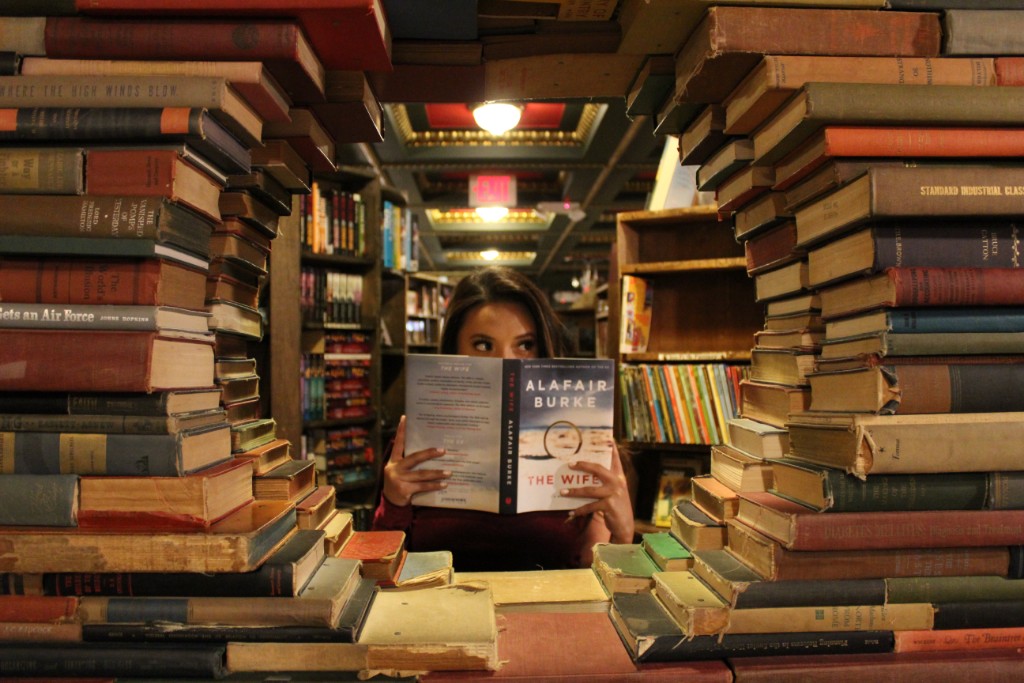 A woman holding a book in a library.