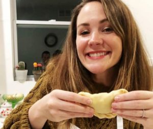 A student holding an empanada at Cozymeal.