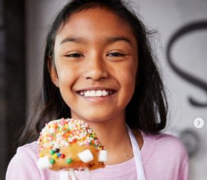 A child holding a cookie in her hand.