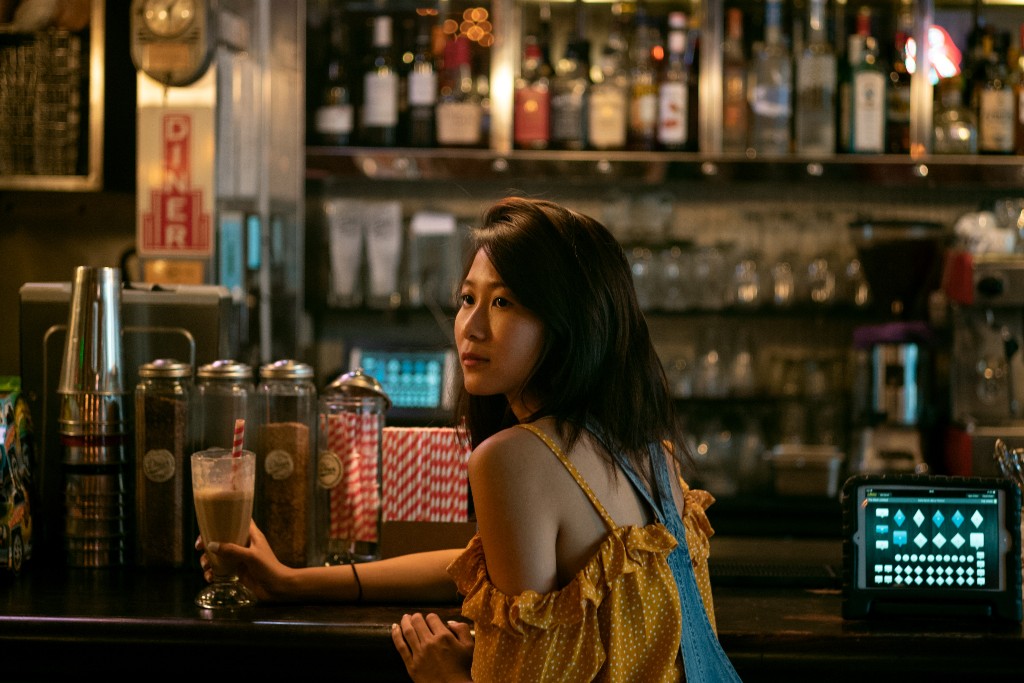 Woman at a bar holding a glass.