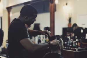 A man giving a haircut to a customer.