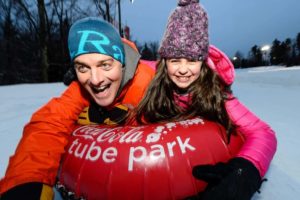 A man and a child having fun at the tube park