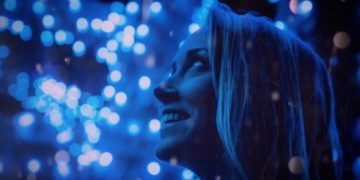 A woman looking up at blue lights