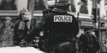 A police officer standing and leaning against a wall