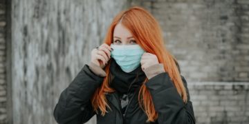 A woman wearing a surgical mask on the street